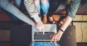 three person pointing the silver laptop computer