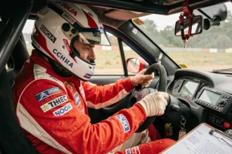 Pilote en combinaison de course dans le cockpit d'une Citroën Saxo VTS lors d'une spéciale de rallye